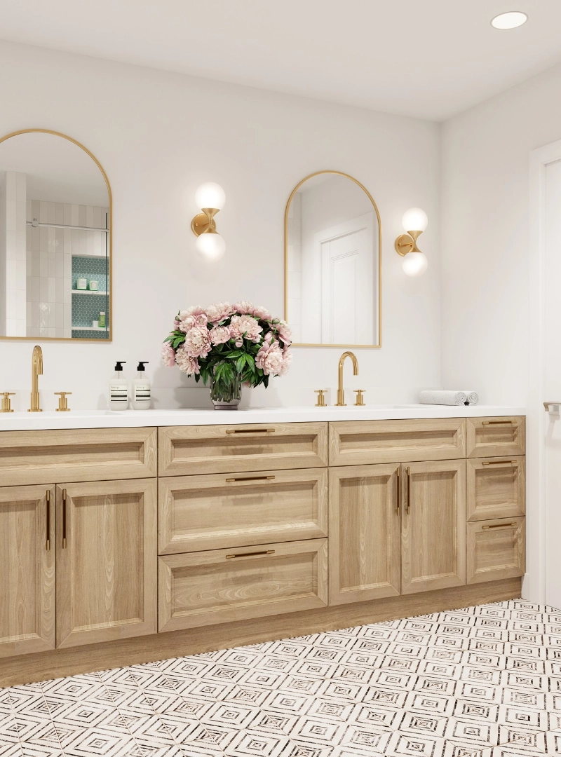 A bathroom from a luxury home remodel showcases a double vanity with wooden cabinets, gold hardware, and matching arched mirrors.