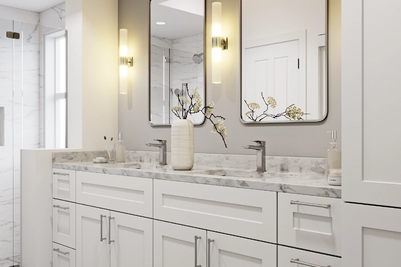 A modern Regency bathroom remodel featuring a white double-sink vanity, marble countertop, wall-mounted mirrors, and two vertical light fixtures. The decor includes a vase with flowers and various toiletries.