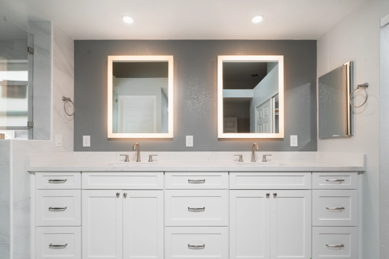 A Regency bathroom remodel features a modern double vanity with two rectangular mirrors, white cabinetry, dual sinks, and a neutral color palette.